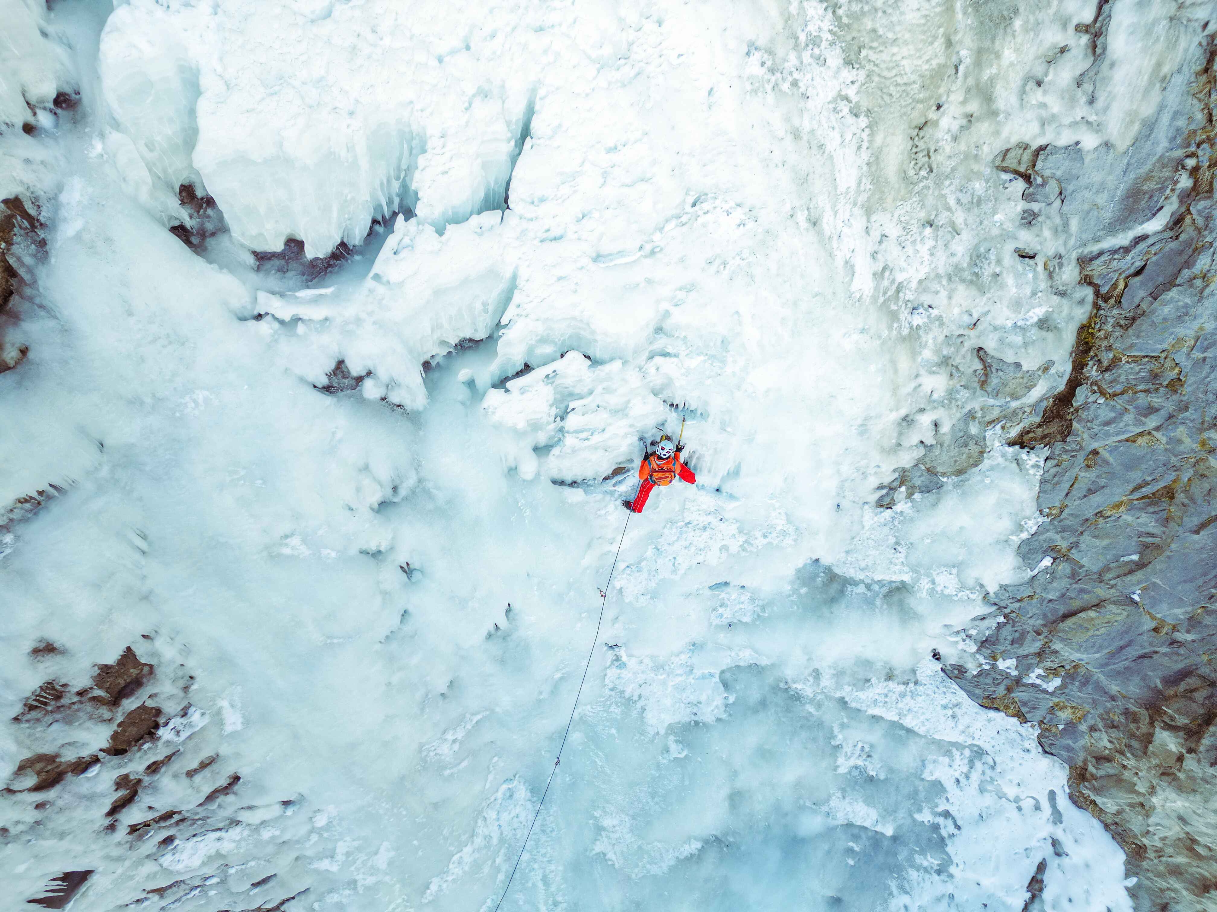 Ice climber ascending a frozen waterfall in Spiti Valley