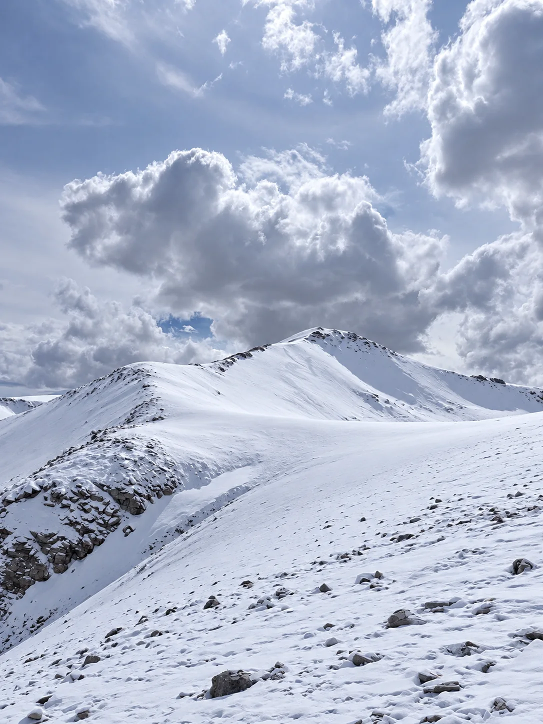 Snow-covered Zes Ri slopes and ridge beneath clouds in Ladakh