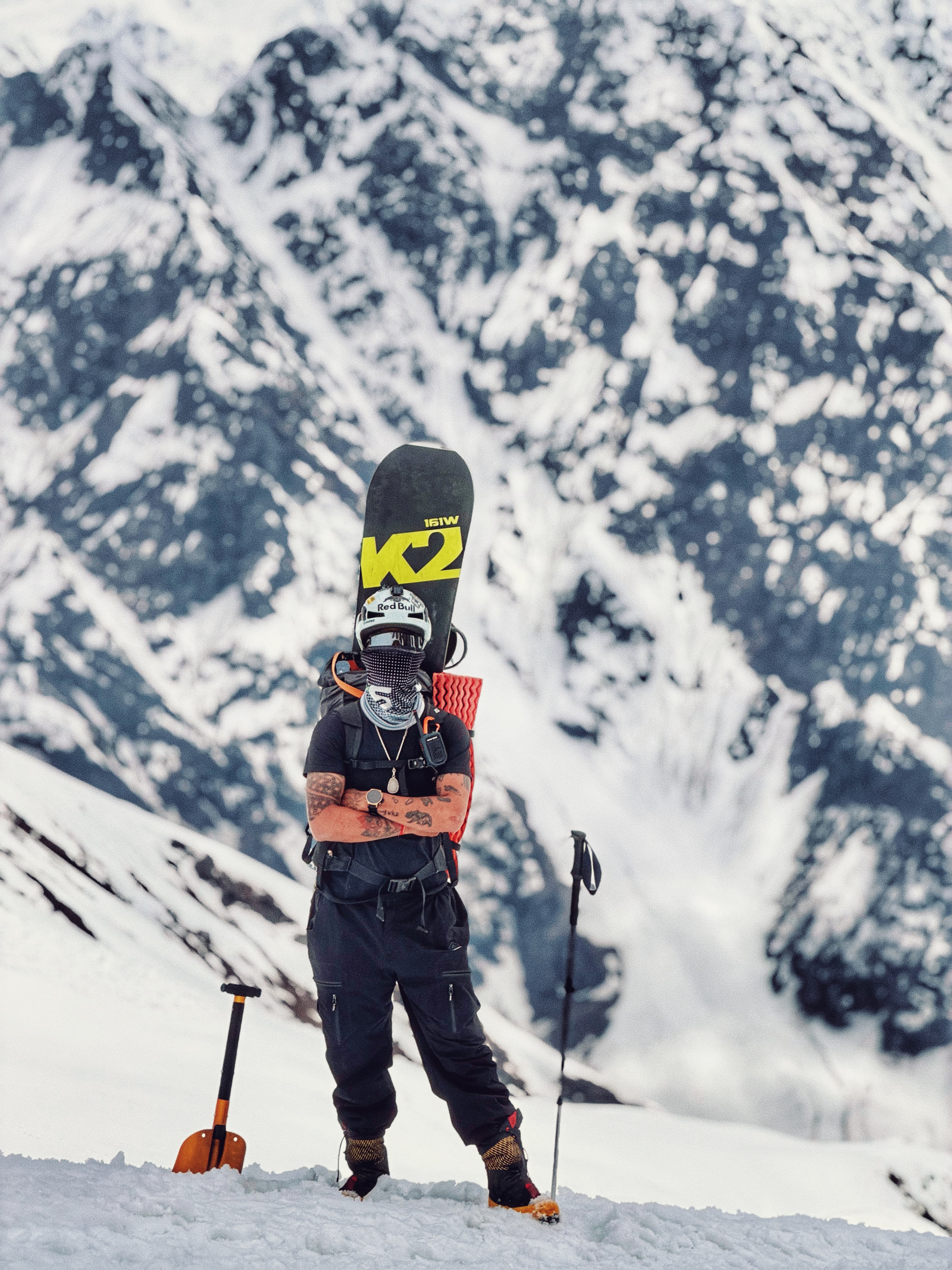 Person carrying a snowboard on a snowy mountain slope