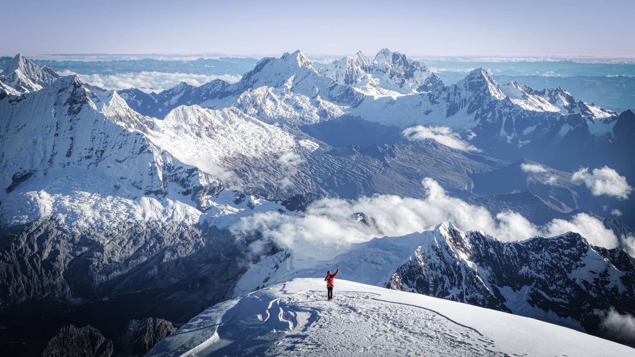Mountaineer on a snow summit overlooking Himalayan peaks during a 5000 meter expedition